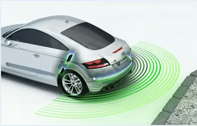 Car reversing with ultrasonic parking sensors detecting a curb and nearby obstacles behind the vehicle